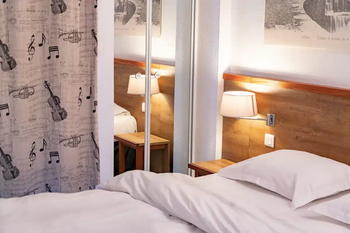 Chambre de l'Hôtel Le Phoebus avec rideaux à motifs musicaux